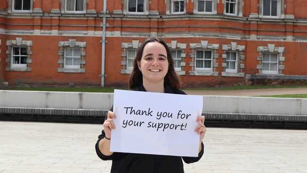 Student holding up a thank you sign